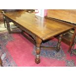 A reproduction oak plank-top dining table on bullet-moulded frieze and turned legs joined by