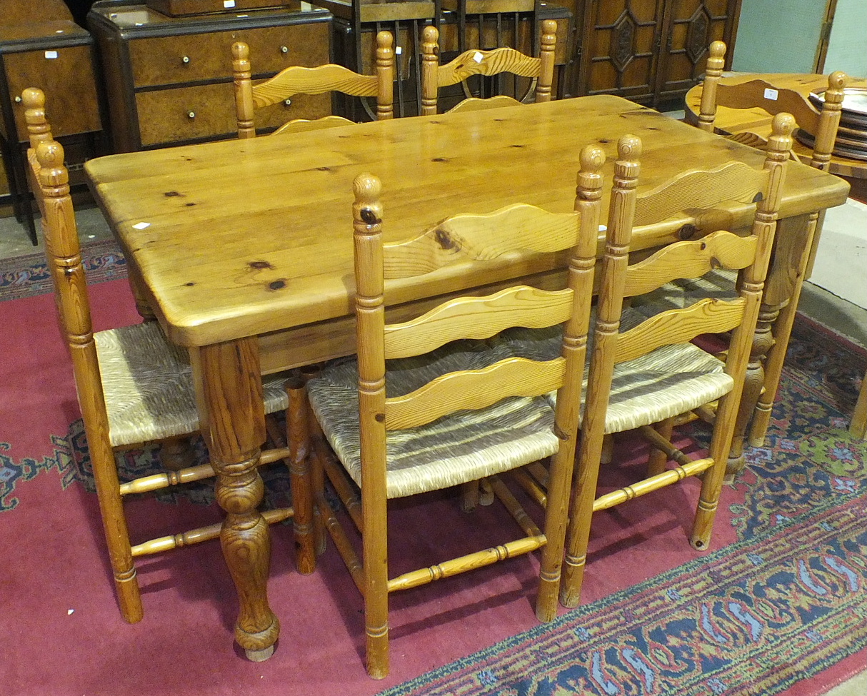 A modern pine rectangular-top kitchen table on turned legs, 141 x 83cm, a set of six pine ladder-