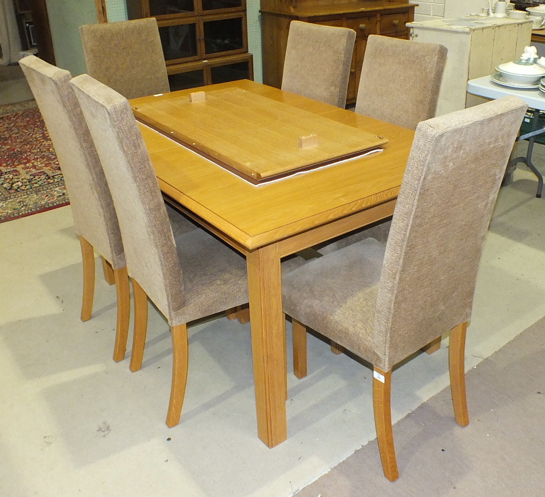 A modern light wood dining table with extra leaf, 194cm wide (extended), 95cm deep and six high-back