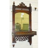 A late-19th/early-20th century walnut-framed hall mirror fitted with a shelf and pierced decoration,