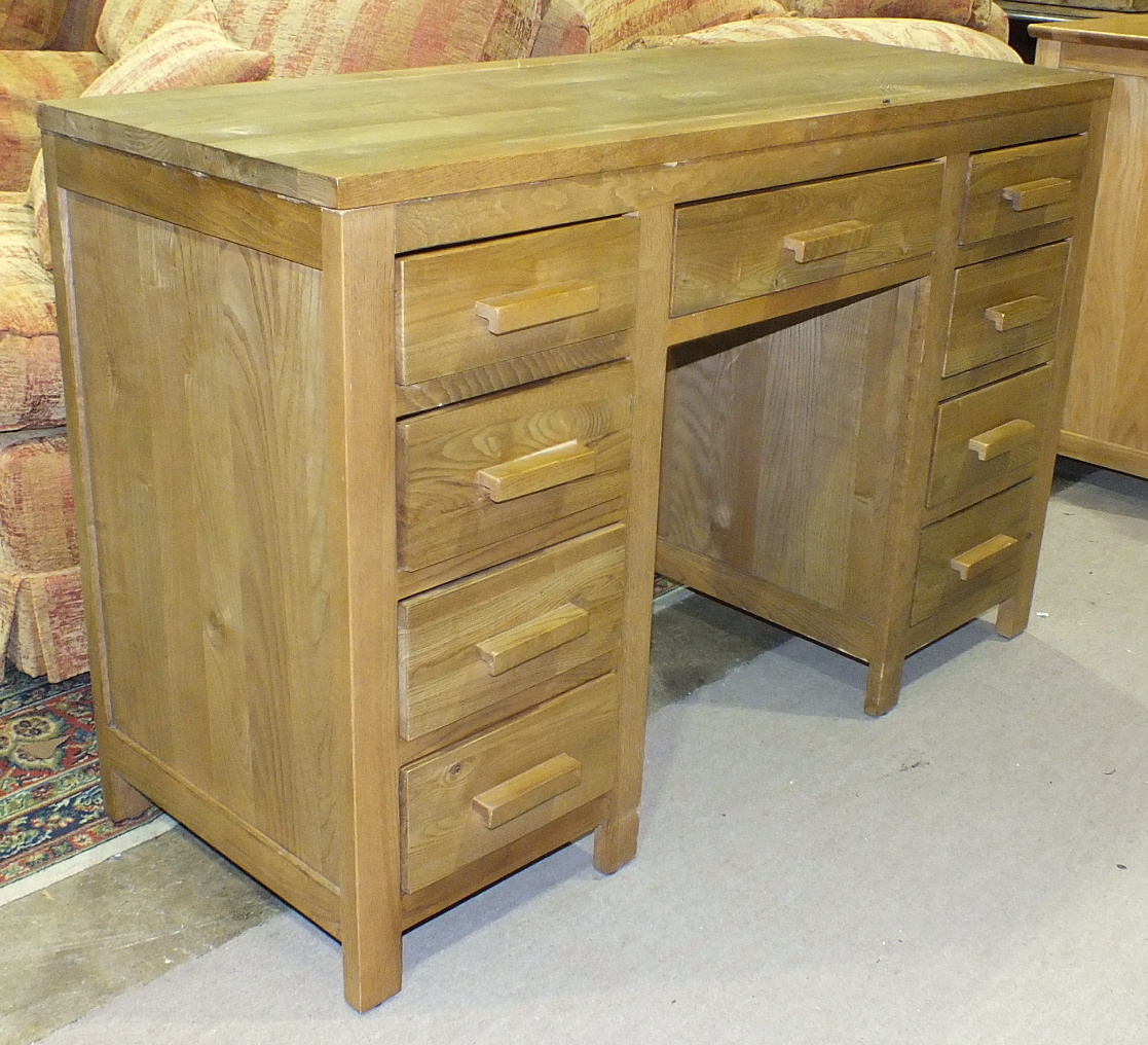 A modern solid light oak knee-hole desk with three frieze drawers and six pedestal drawers with wood
