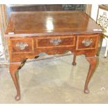 A walnut feather-banded lowboy in the 18th century style fitted with three drawers, on cabriole