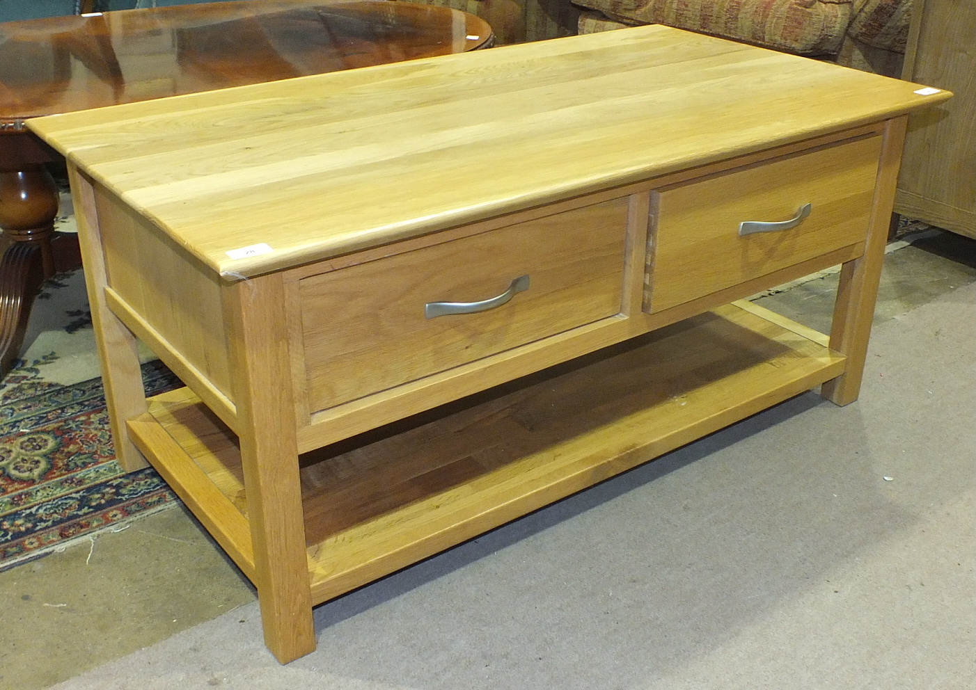 A modern light wood TV unit with two drawers and base shelf, 110cm wide, 50cm high, 59cm deep.