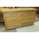A modern light oak chest of three short and four long drawers with brushed handles, 138cm wide, 77cm