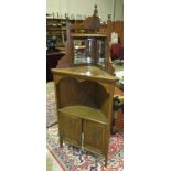 An Edwardian walnut corner cupboard, the mirrored back above a shelf and a pair of cupboard doors,