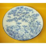 A large Arita blue and white charger decorated with birds and flowering trees, 57cm diameter.