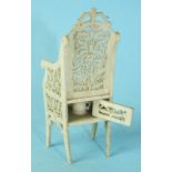 A Victorian carved ivory novelty miniature armchair with pierced carved back and seat opening at