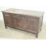 An antique oak panelled coffer, the hinged lid above three fielded panels, initialled ST and dated