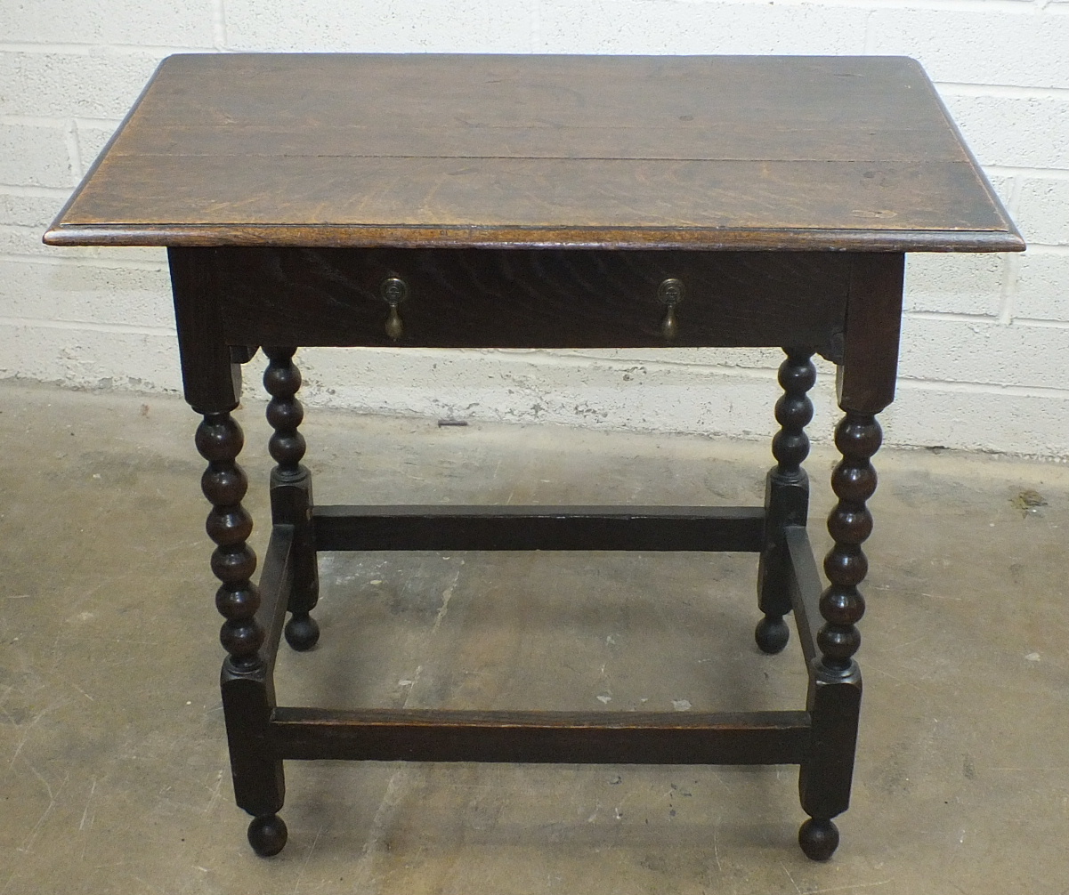 An antique oak sideboard, the rectangular top above a frieze drawer on bobbin-turned legs joined