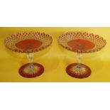 A pair of Victorian cranberry glass overlay tazzas, each on a large star-cut base, 22cm diameter,