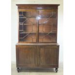 A Colonial hardwood bookcase, the cornice above a pair of astragal glazed doors and a pair of