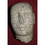 A pink granite carved head, 34cm high, 22cm wide, (damage to nose).