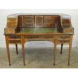 An Edwardian Carlton House style writing desk having an arrangement of drawers and cupboards above