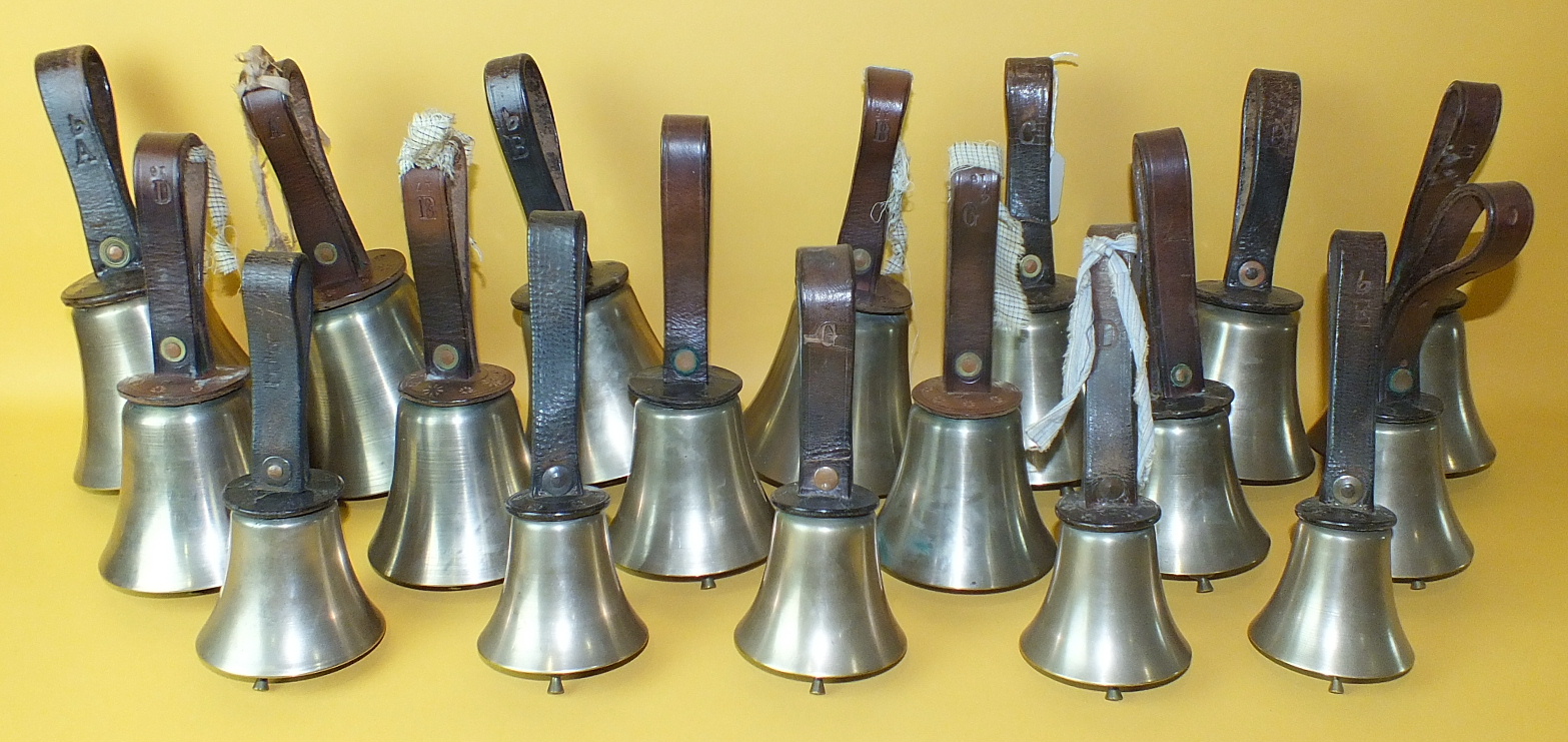 A set of eighteen bronze hand bells with leather straps, complete with sheet call-change music and a