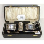 A cased George V three piece silver cruet set, comprising salt, pepper and mustard pot with