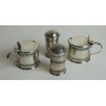 A pair of Edwardian silver lidded mustard pots with pierced and engraved decoration and a pair of