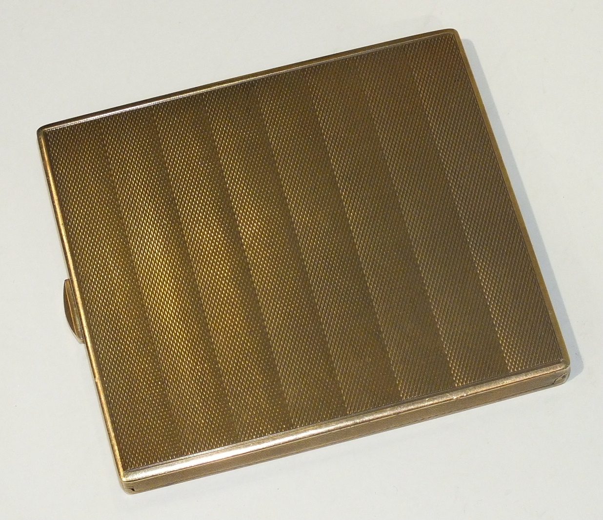 "The Belvoir", a 9ct yellow gold cigarette case with engine-turned decoration, 9x8cm, 136g.