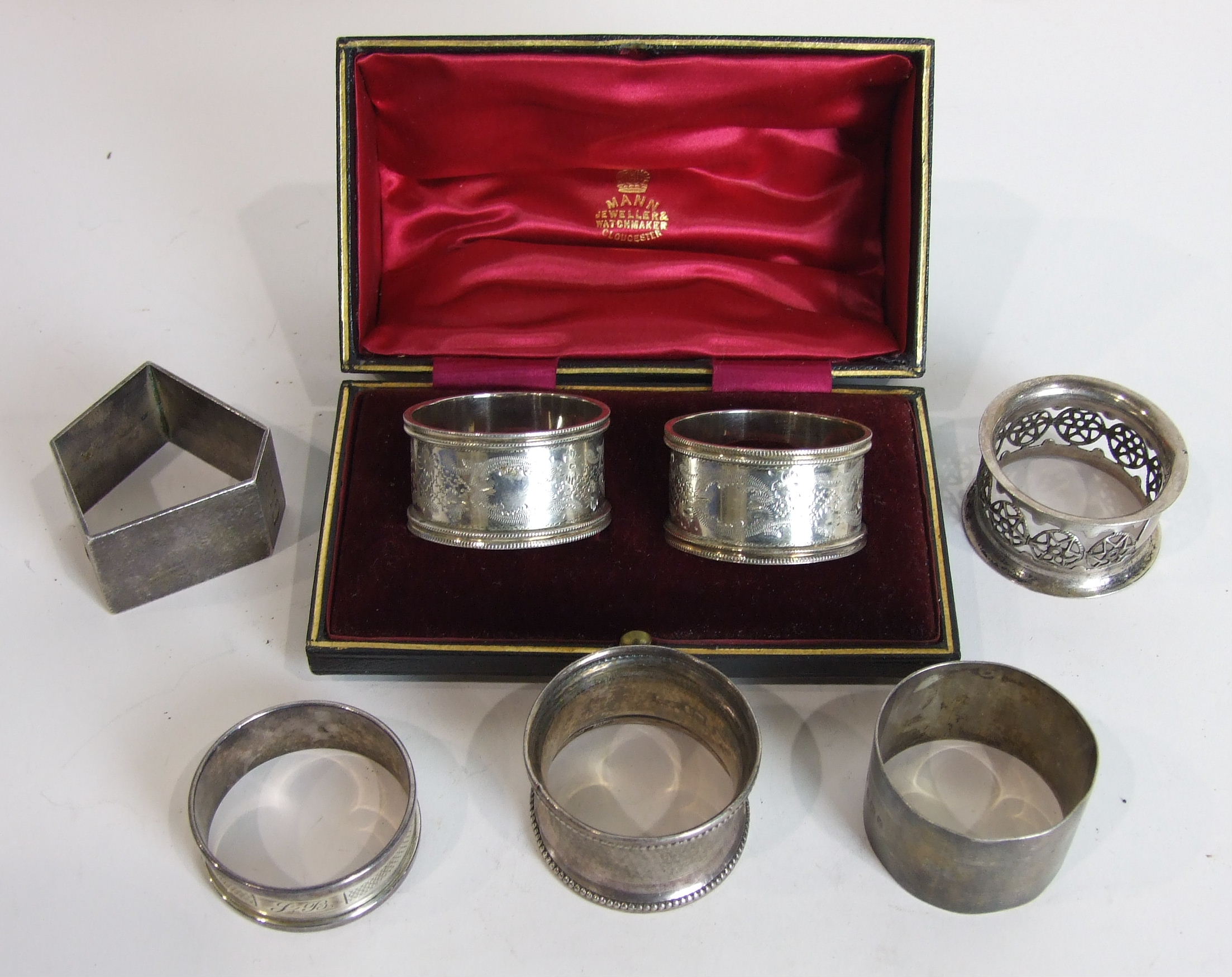 A cased pair of engraved silver napkin rings, Sheffield 1909, a silver napkin ring by Christopher