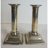 A pair of silver candlesticks of plain column form on square beaded bases, Sheffield (marks rubbed),