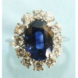 A sapphire and diamond cluster ring, the oval sapphire of approximately 4cts claw set within a