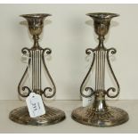 A pair of loaded silver candlesticks of lyre form on oval bases, 21cm high.