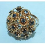 A large 18ct gold dress ring set a cluster of sixteen flower motifs, each centred by a round cut