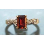 A modern 9ct gold ring claw set a garnet between diamond point set shoulders, size K½, 2g.