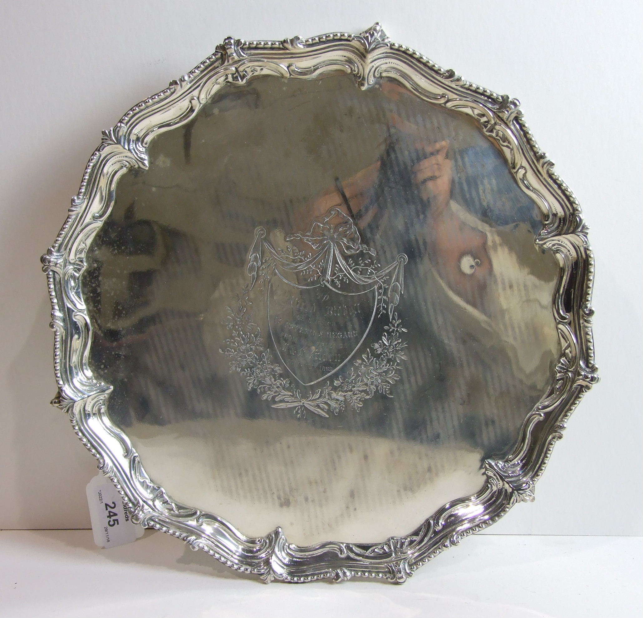 A George III silver salver with scroll and bead borders, raised on three claw and ball feet, maker