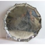 A George III silver salver with scroll and bead borders, raised on three claw and ball feet, maker