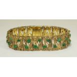 A 14k yellow gold bracelet of textured and pierced linked plaques, each set with two jade cabochons,