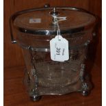 An oval glass biscuit barrel with etched floral decoration and plated mount, lid and stand with