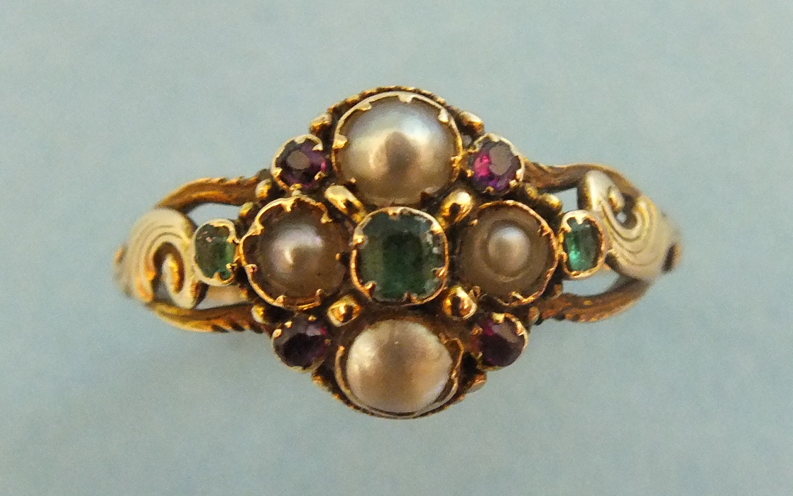 An early 19th century mourning ring set a cluster of pearls and red and green stones with locket