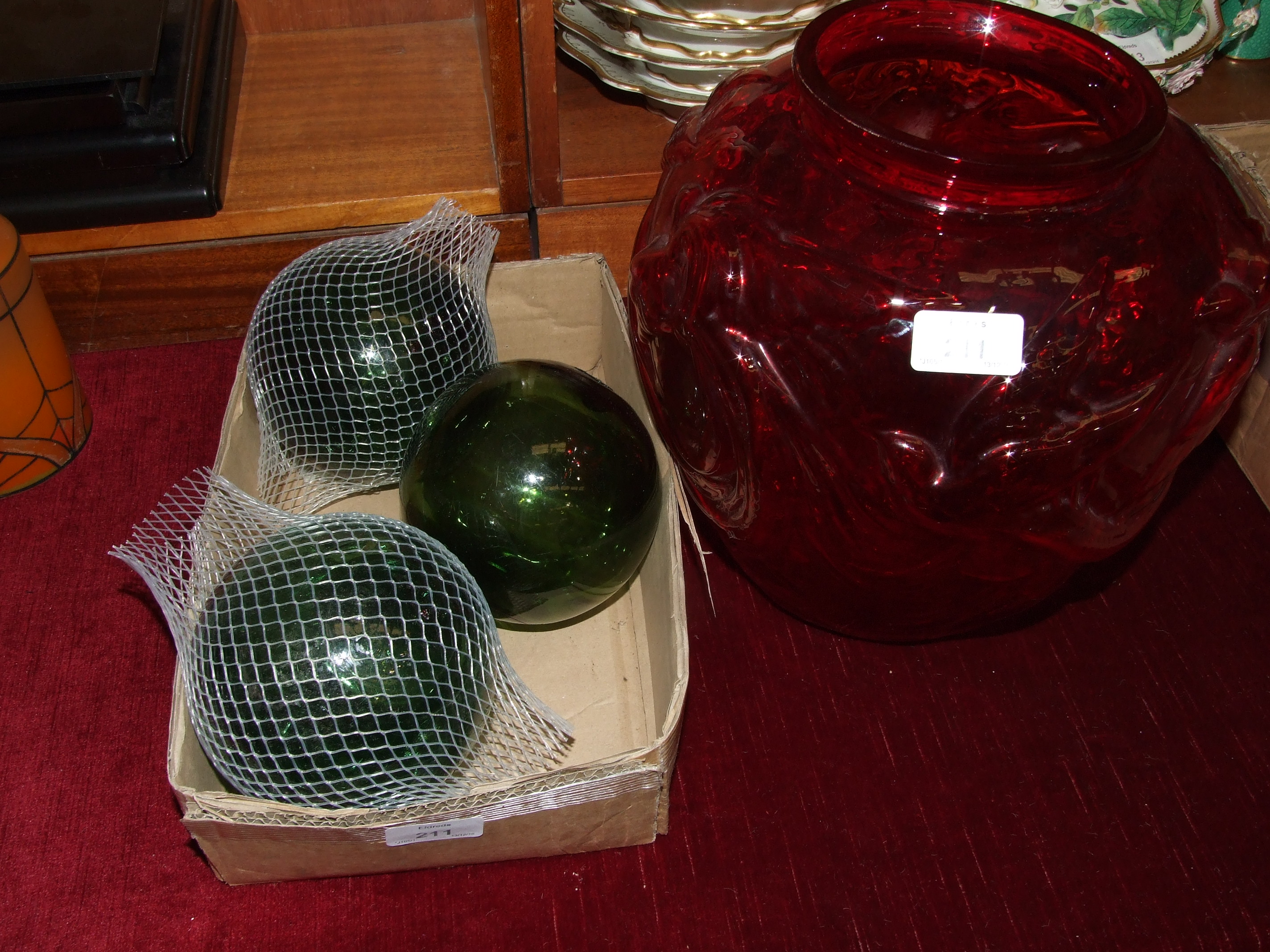 A large bulbous red glass vase with raised decoration of birds in flight, 24cm diameter, 28cm high