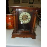 A stained wood striking mantel clock, 36cm high.