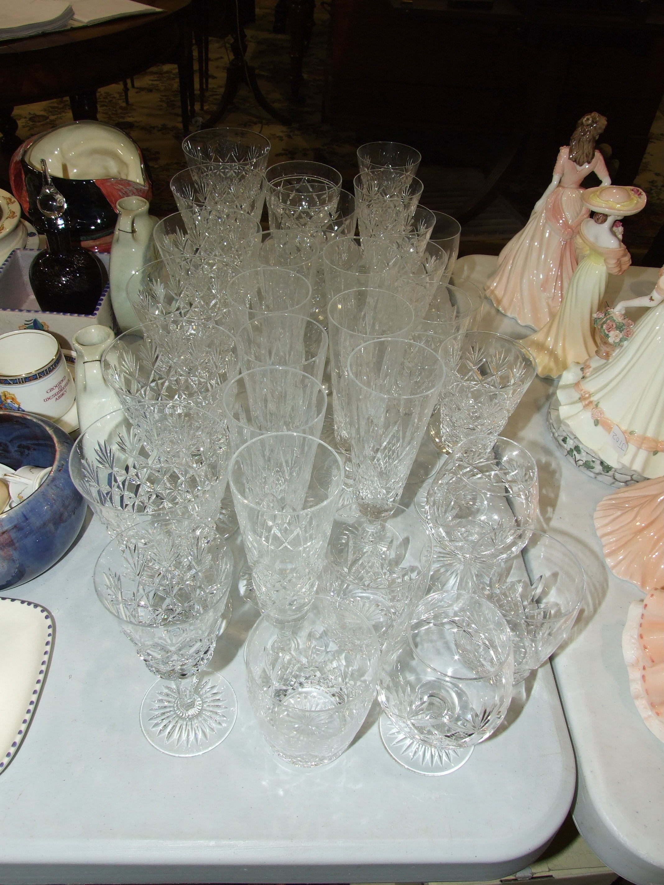 Six large cut glass wine glasses, six champagne flutes and other drinking glasses.