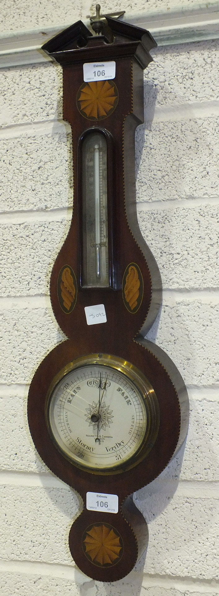 An inlaid mahogany aneroid barometer and thermometer with silvered dial, marked Negretti & Zambra,