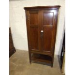 An early 20th century mahogany music cabinet, having a pair of panel doors enclosing ten shelves,