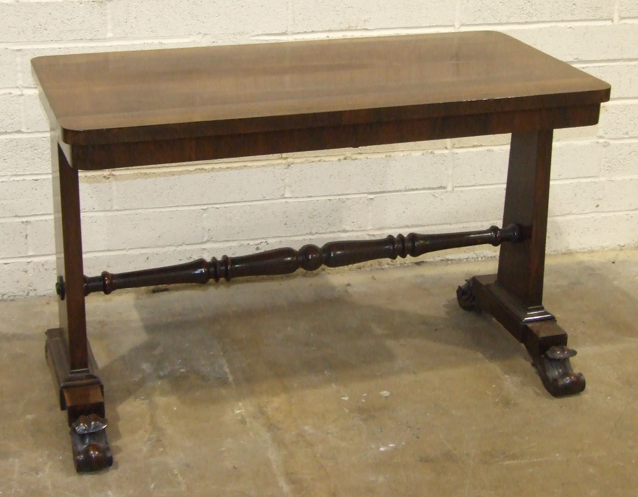 A William IV rosewood centre table, the rectangular top raised on tapered end supports with carved