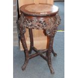 A Chinese carved hardwood urn stand, the shaped circular top with beaded border and marble panel, on