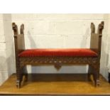 A Scandinavian stained wood hall seat, the ends carved as mythical beasts, 113cm.