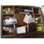 A wooden box containing a quantity of curio items to include pin badges, military buttons,