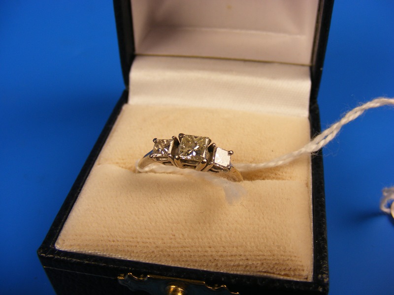 A white gold 18ct (unmarked) three stone square cut diamond ring