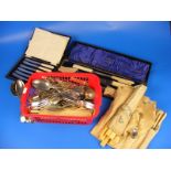 A cased carving set together with another case of knives and a large assortment of cutlery