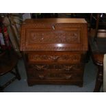 A heavily carved oak bureau