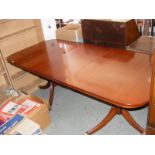 A mahogany dining table with extra leaf