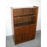 A teak display cabinet over cupboard base with sliding doors