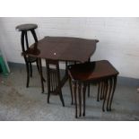 A mahogany dropleaf tea table together with a nest of three tables and a hardwood carved plant