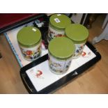 Four retro storage tins together with a tiled serving tray