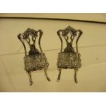 A pair of miniature silver chairs