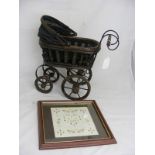 A vintage decorative small pram together with a modern cross stitch sampler